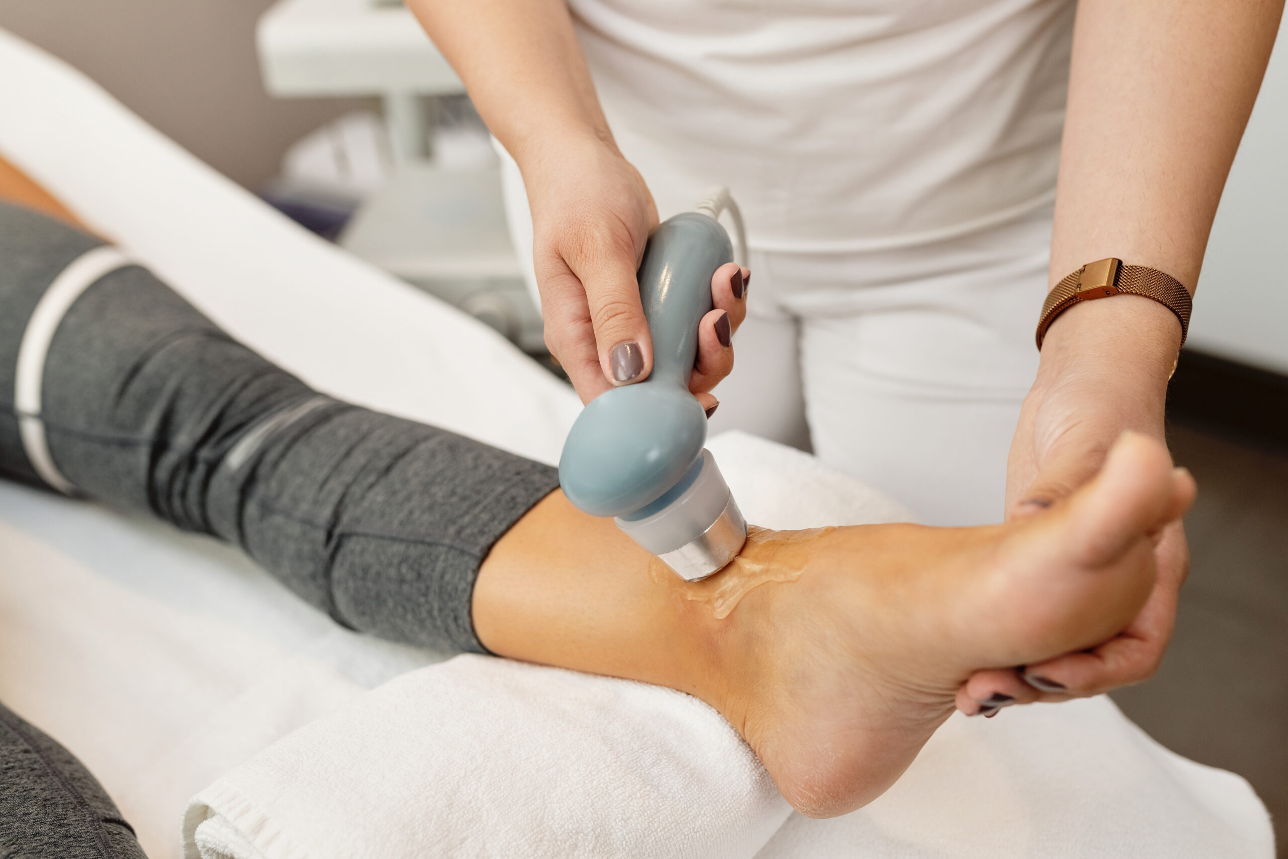 Close-up of physical therapist treating client's joint with elec